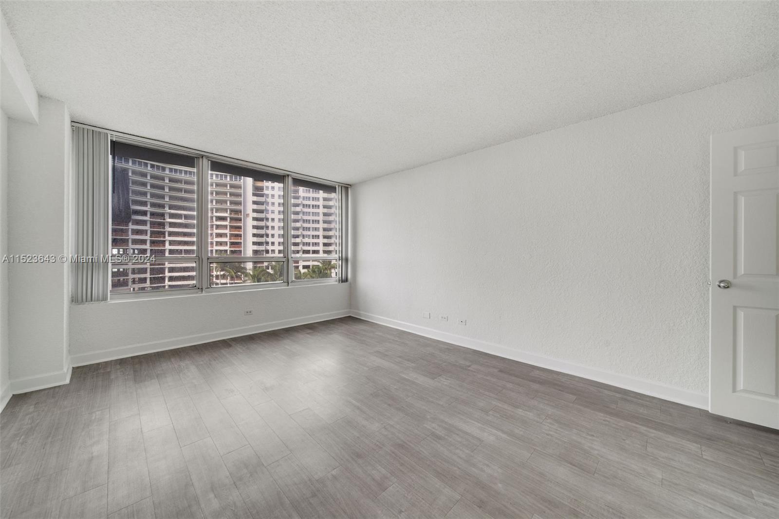 1500 Bay Road, Unit S0354 Miami Beach, FL 33139 - Photo 13 of 78 a view of an empty room with wooden floor and a window