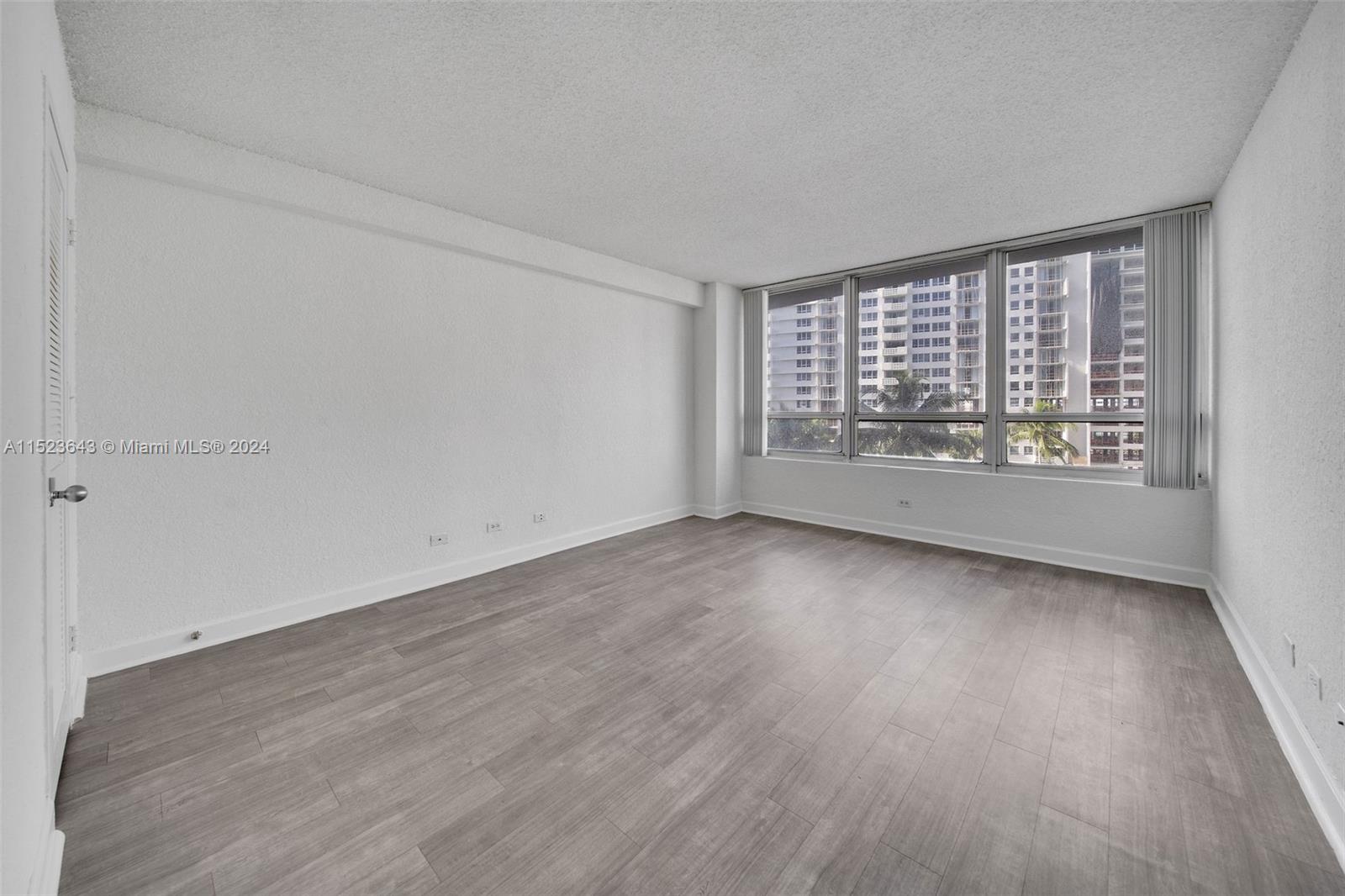 1500 Bay Road, Unit S0354 Miami Beach, FL 33139 - Photo 14 of 78 an empty room with wooden floor and windows
