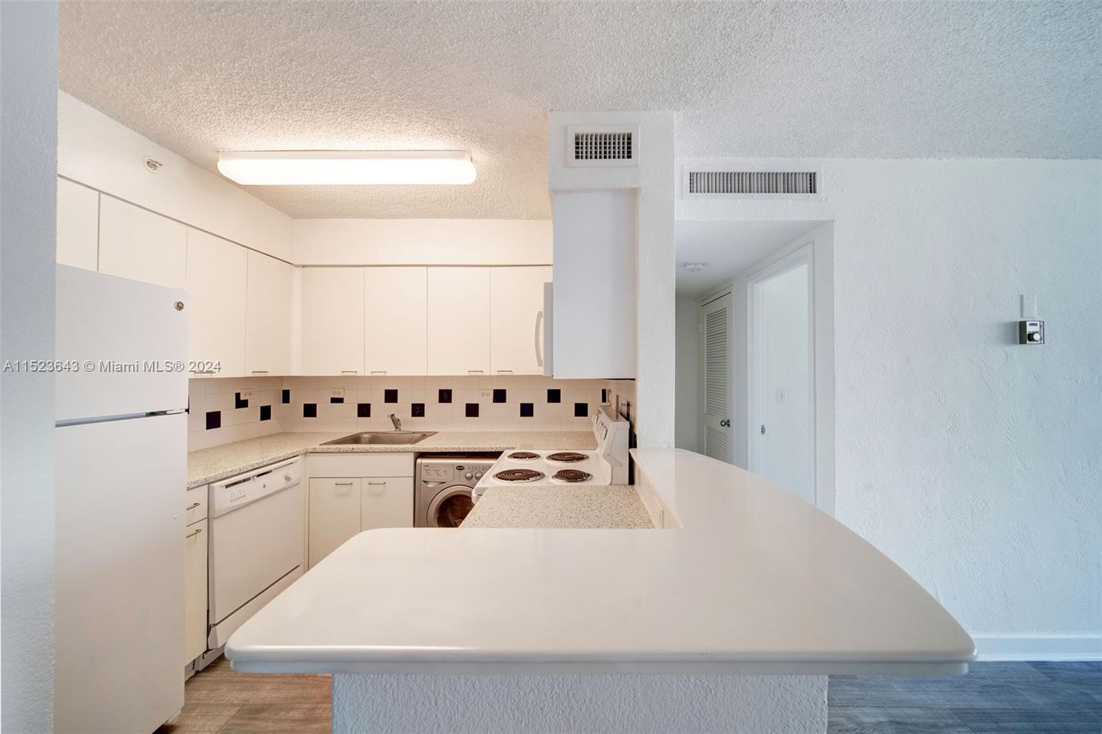 1500 Bay Road, Unit S0354 Miami Beach, FL 33139 - Photo 7 of 78 a white kitchen with a sink a stove and white cabinets