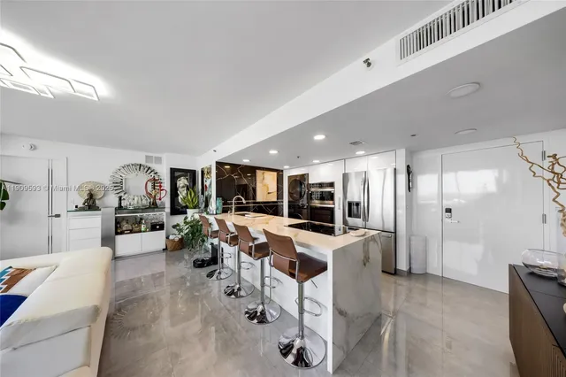 a living room with furniture a large window and kitchen view