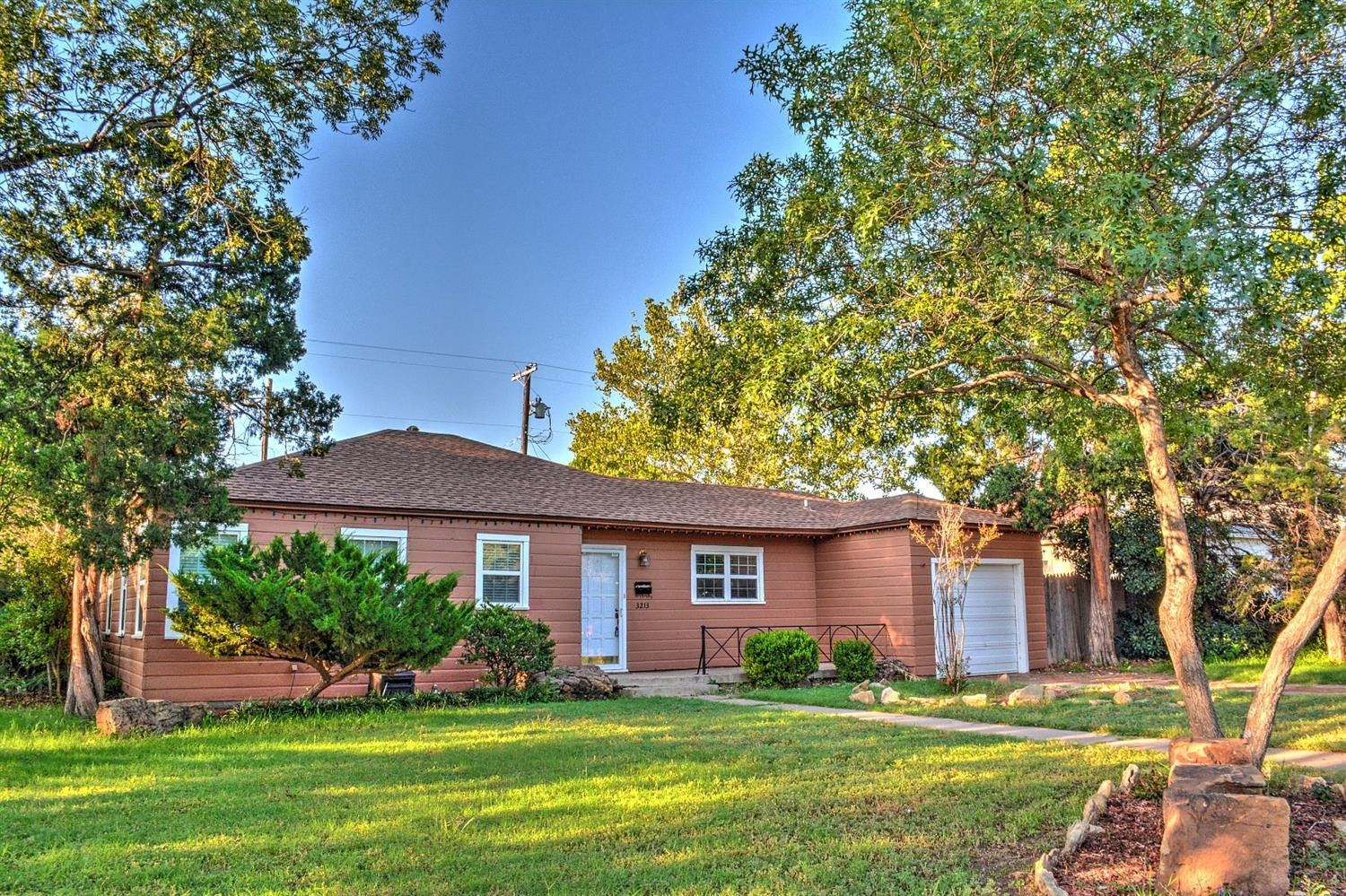 a front view of a house with a garden