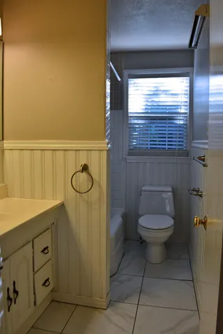a bathroom with a toilet sink and window