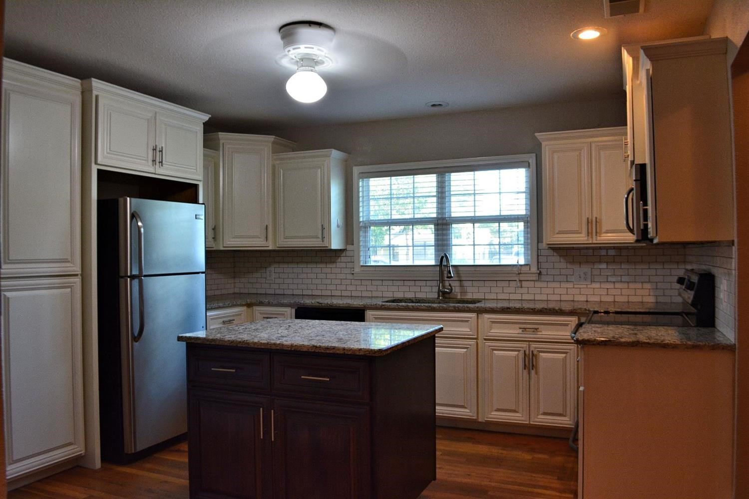 3213 26th Street Lubbock, TX 79410 - Photo 4 of 20 a kitchen with a sink stove and refrigerator