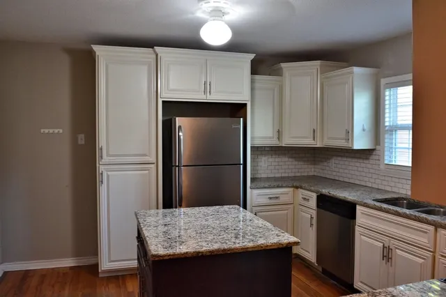 a kitchen with a sink refrigerator and microwave