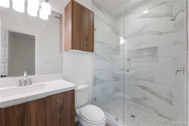 a bathroom with a sink a toilet and shower