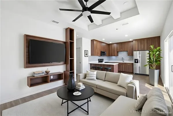 a living room with furniture kitchen view and a flat screen tv