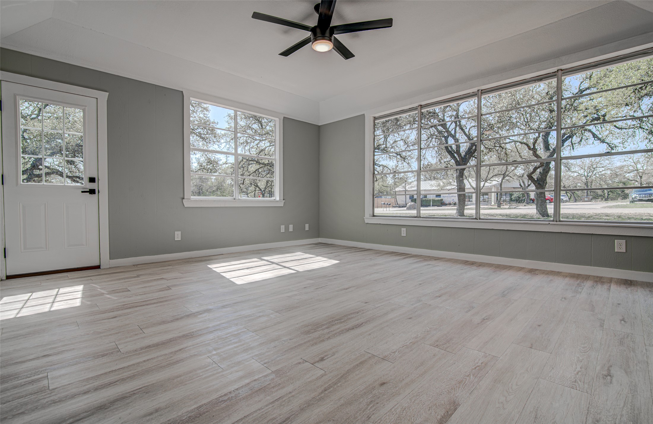 207 Haley Road Johnson City, TX 78636 - Photo 21 of 31 Natural light floods this living area through abundant windows, showcasing the durable tile flooring.