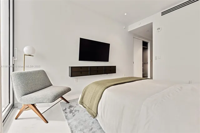 a bedroom with a bed and chair