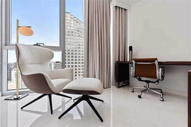 a view of a workspace with furniture and a window