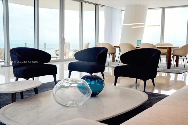 a living room with furniture and floor to ceiling windows