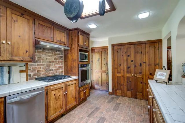 a kitchen with stainless steel appliances granite countertop a refrigerator and a sink