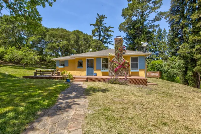 a view of a house with backyard sitting area and garden