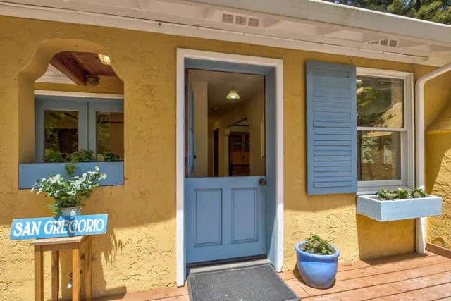 a front view of a house with potted plants