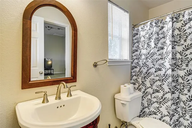 a bathroom with a sink a toilet and a mirror