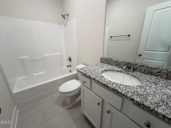 a bathroom with a granite countertop sink a toilet and a mirror