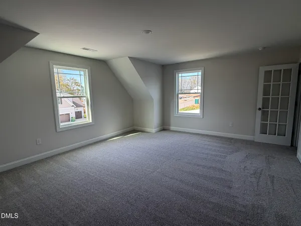 an empty room with windows and closet
