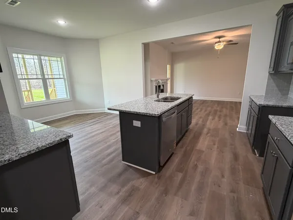 a kitchen with granite countertop a sink and a stove top oven