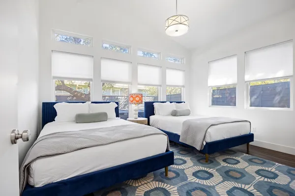 a bedroom with two beds and a large window