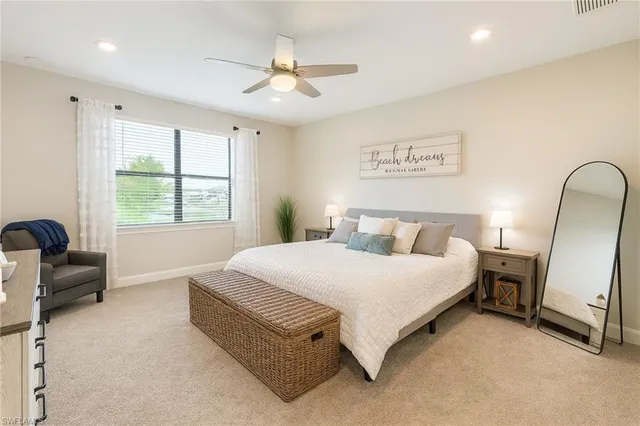 a spacious bedroom with a bed a couch and a window