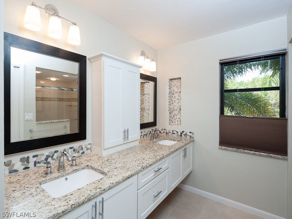 1631 Sand Castle Road Sanibel, FL 33957 - Photo 14 of 25 a bathroom with a granite countertop sink and a mirror
