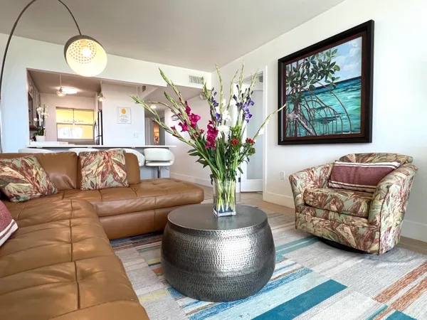 a living room with a couch and potted plant with wooden floor