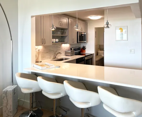 a kitchen with stainless steel appliances a sink a stove a refrigerator a counter top space and cabinets