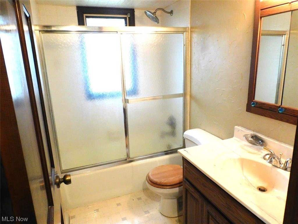 1102 Fiesta Road Southwest Dellroy, OH 44620 - Photo 15 of 20 Full bathroom with combined bath / shower with glass door, toilet, tile flooring, and vanity with extensive cabinet space