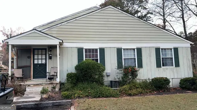 a view of a white house next to a yard