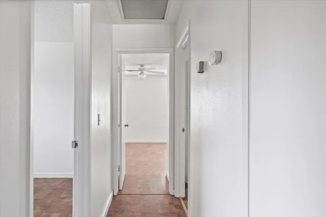 an empty room with a window and a fan