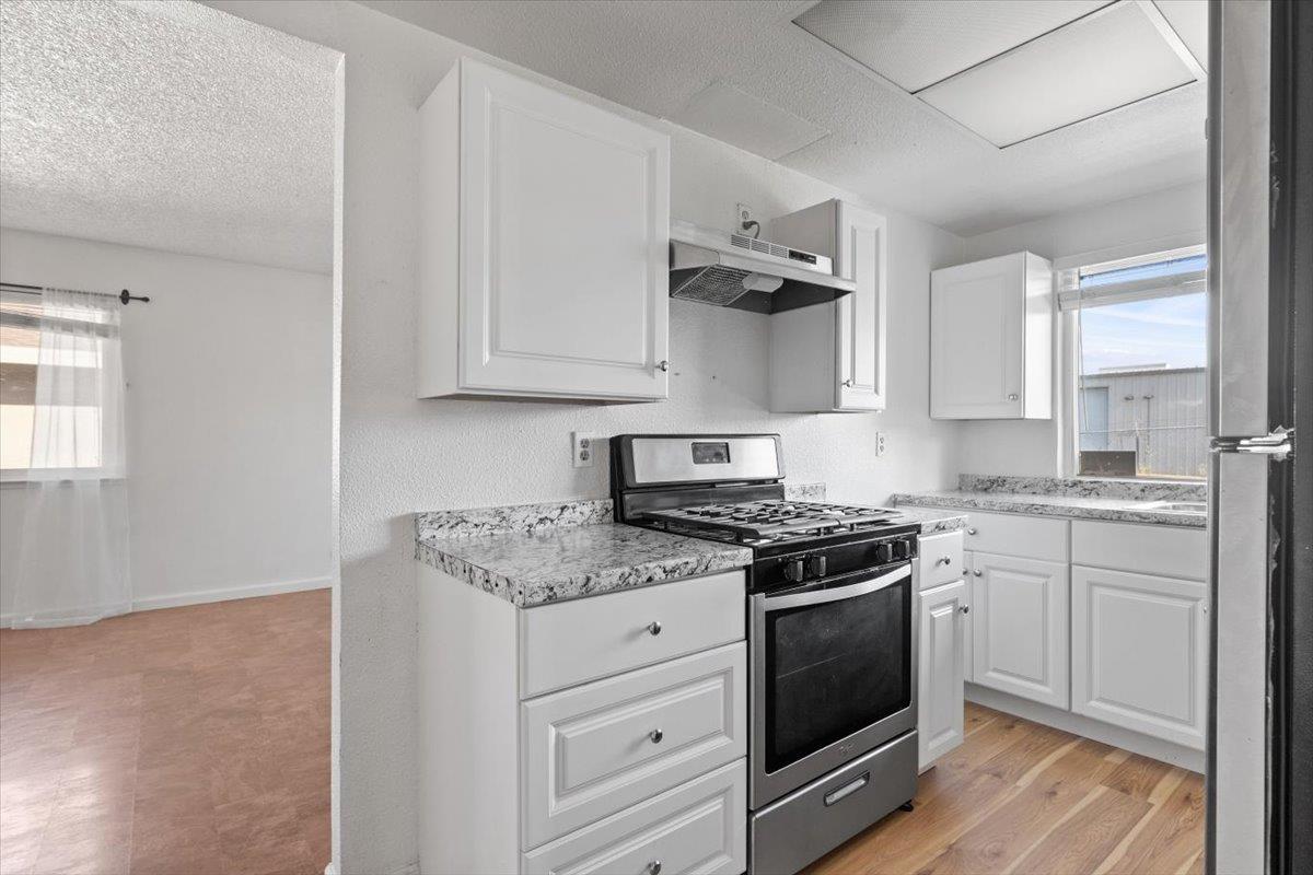 11570 Garnet Way, Unit 4 Auburn, CA 95602 - Photo 19 of 44 a kitchen with stainless steel appliances granite countertop a stove a sink and white cabinets