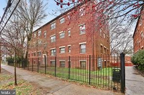a view of a white house with a large trees