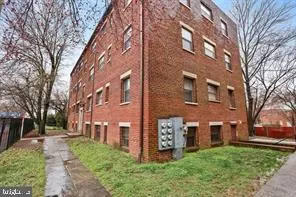 a brick building with a yard in front of it
