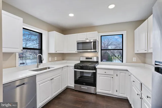 a kitchen with white cabinets and white appliances