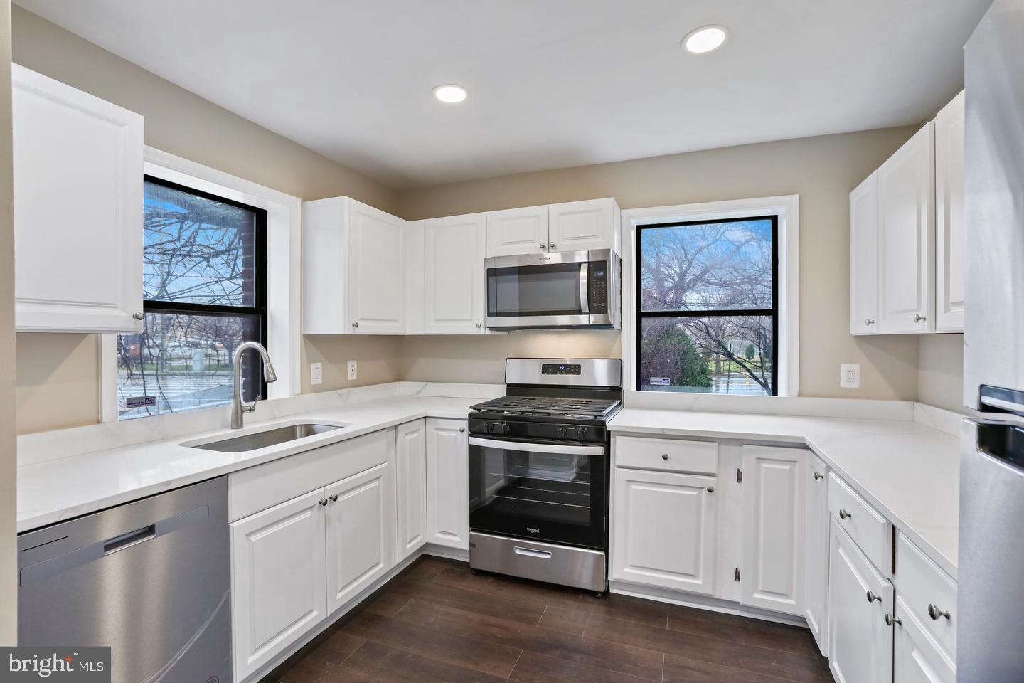 3287 15th Place Southeast, Unit 101 Washington, DC 20020 - Photo 5 of 16 a kitchen with white cabinets and white appliances
