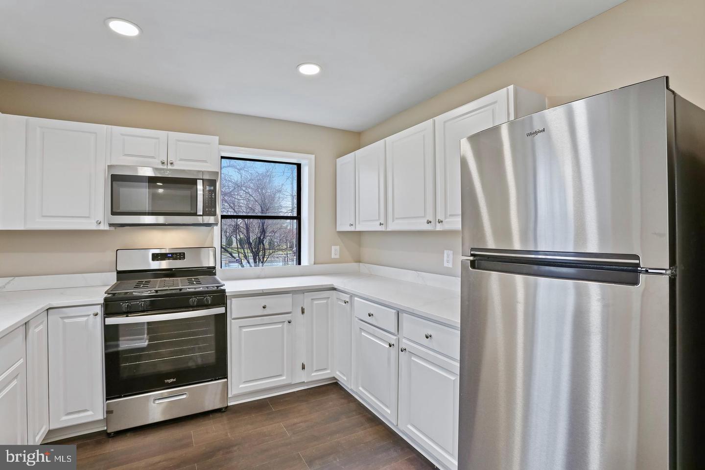 3287 15th Place Southeast, Unit 101 Washington, DC 20020 - Photo 6 of 16 a kitchen with white cabinets and stainless steel appliances