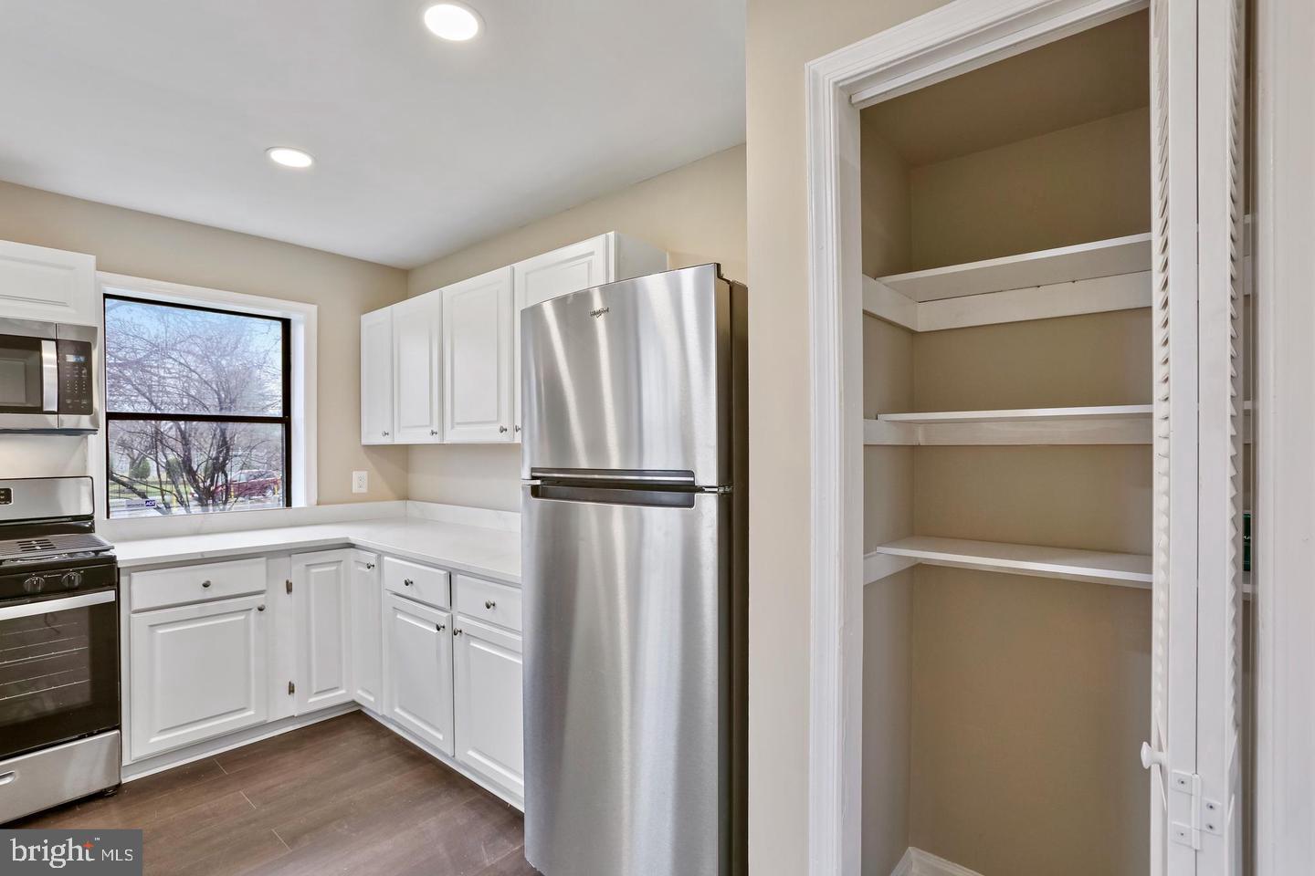 3287 15th Place Southeast, Unit 101 Washington, DC 20020 - Photo 7 of 16 a kitchen with white cabinets and white appliances