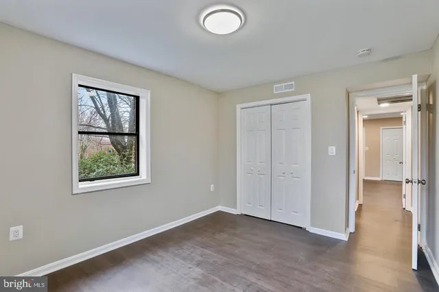 an empty room with windows and closet