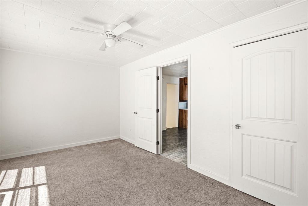 1040 Clinton Avenue Stephenville, TX 76401 - Photo 17 of 26 an empty room with a ceiling fan and a window