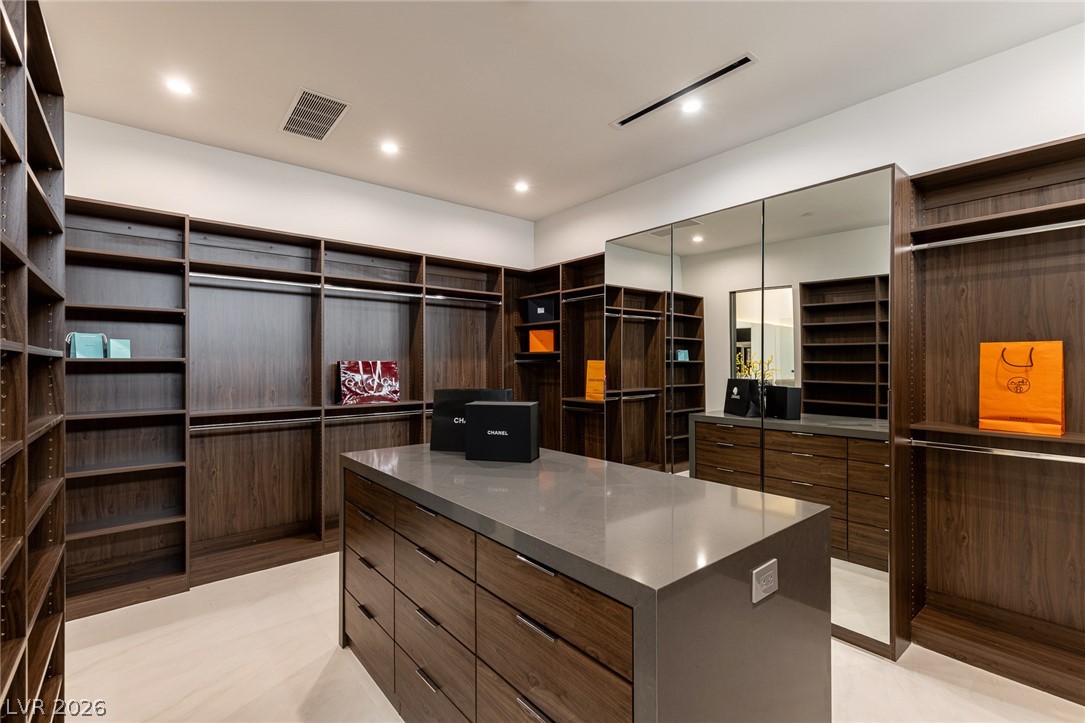 563 Grand Rim Drive Henderson, NV 89012 - Photo 26 of 70 Custom cabinetry and generous shelving create a highly organized walk-in closet with abundant storage.