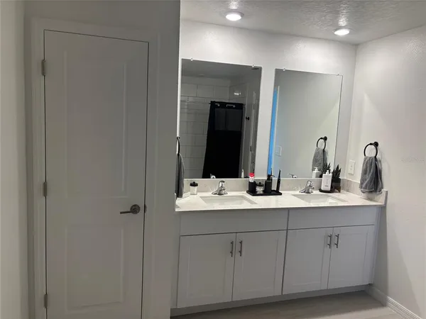a bathroom with double sink and a mirror