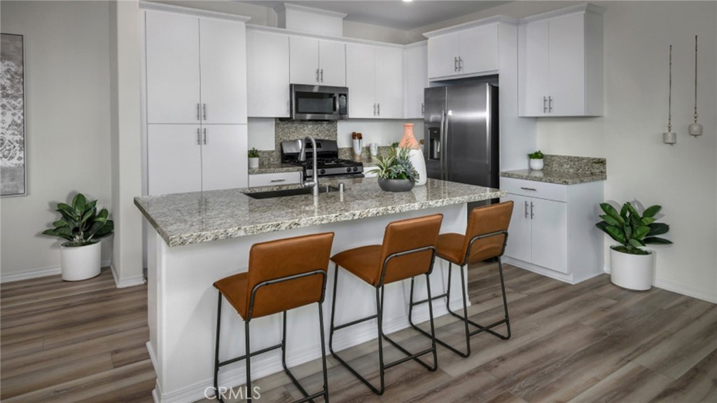 a kitchen with stainless steel appliances granite countertop sink stove top oven and microwave
