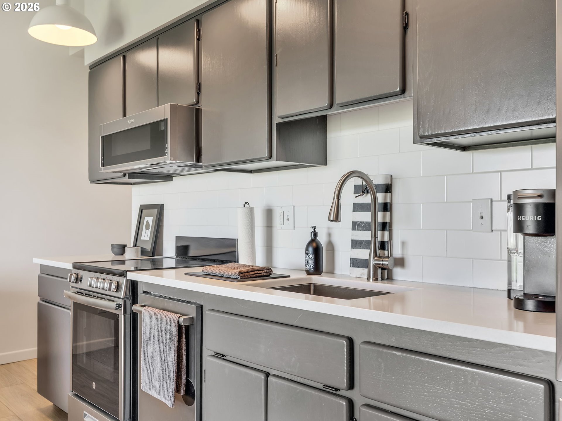 101 13th Street, Unit 211 Gearhart, OR 97138 - Photo 11 of 24 a kitchen with stainless steel appliances a sink a stove and a microwave