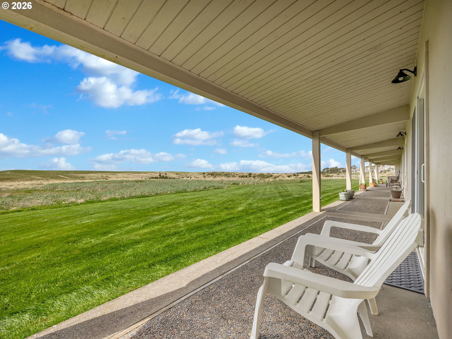 101 13th Street, Unit 211 Gearhart, OR 97138 - Photo 19 of 24 a view of a two chairs in the patio next to a yard