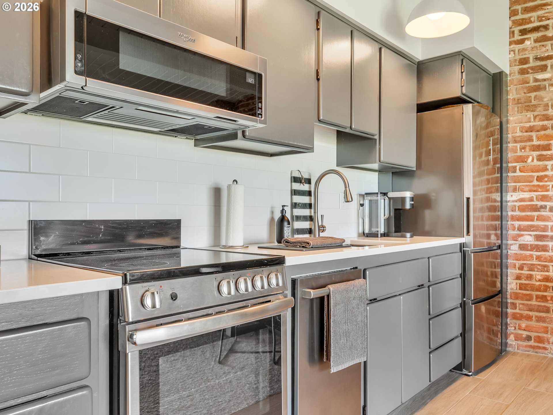 101 13th Street, Unit 211 Gearhart, OR 97138 - Photo 8 of 24 a kitchen with stainless steel appliances granite countertop a sink a stove and a microwave