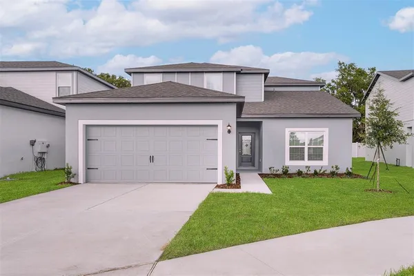 a front view of a house with a yard and garage
