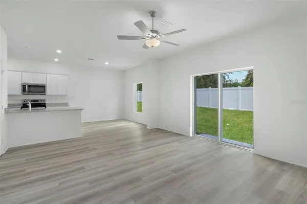 a view of an empty room with a window and wooden floor
