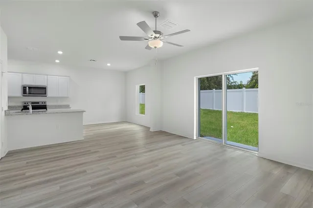 a view of an empty room with a window and wooden floor