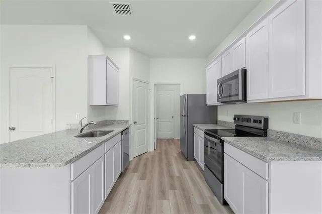 a kitchen with stainless steel appliances granite countertop a sink stove and refrigerator