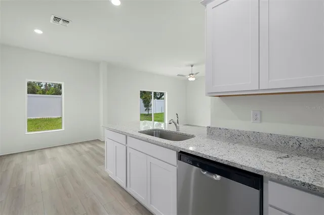 a kitchen with granite countertop a sink and cabinets