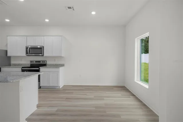 a kitchen with sink a microwave and cabinets